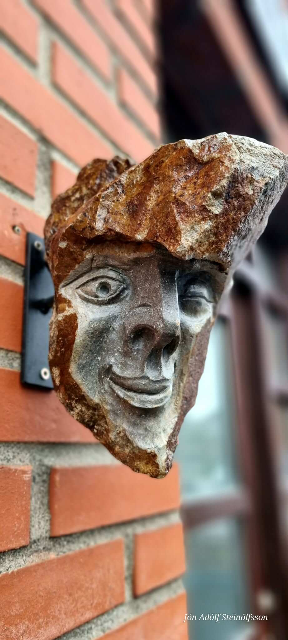 Icelandic stone face sculpture with one carved eye by Jón Adólf Steinólfsson